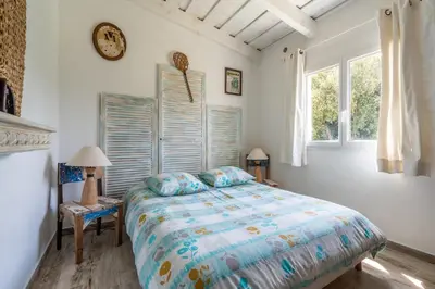 a bedroom with a bed and a clock on the wall at La bergerie 1 in Bonifacio