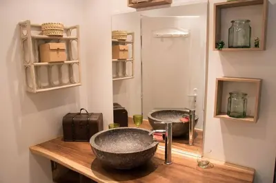 a bathroom with a bowl sink on a wooden counter at La bergerie 1 in Bonifacio