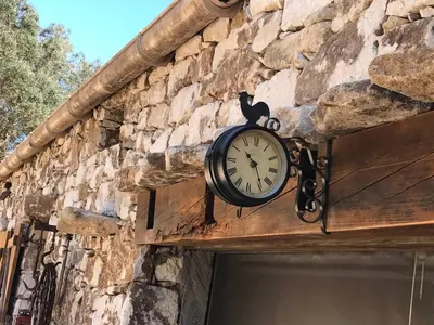 a clock on the side of a stone building at La bergerie 1 in Bonifacio