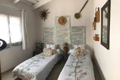 two twin beds in a room with two windows at La bergerie 1 in Bonifacio