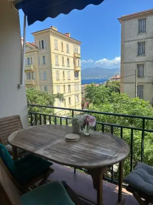 a table on a balcony with a view of a building at Jolie appartement ville in Ajaccio