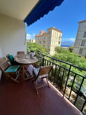 a balcony with a table and chairs and a view at Jolie appartement ville in Ajaccio