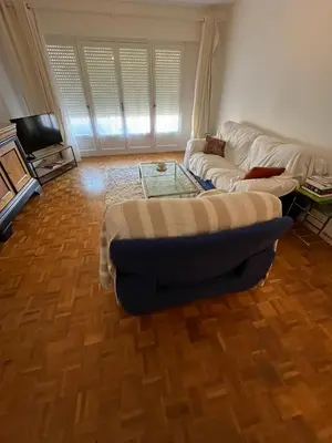 a living room with a couch and a tv and a table at Jolie appartement ville in Ajaccio