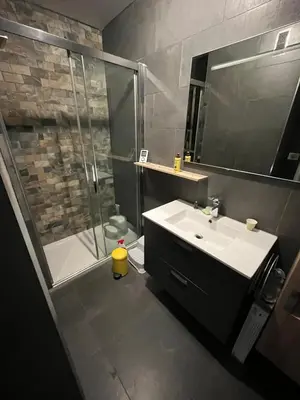 a bathroom with a sink and a shower with a glass door at Jolie appartement ville in Ajaccio