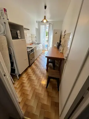 a kitchen with a wooden floor and a table at Jolie appartement ville in Ajaccio