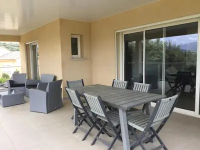 a wooden table and chairs on a patio at Locations I Carboni - villa 3 chambres in Sollacaro
