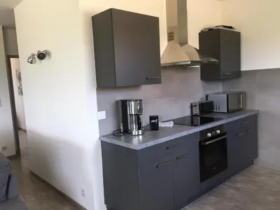 a kitchen with black cabinets and a counter top at Locations I Carboni - villa 3 chambres in Sollacaro