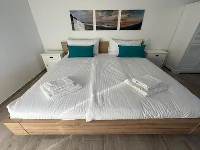 a large white bed with blue pillows on it at Vacation home near Porto Vecchio in Porto-Vecchio