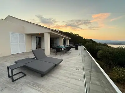 a deck with a couch and chairs on a house at Vacation home near Porto Vecchio in Porto-Vecchio