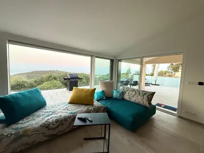 a living room with a couch and a large window at Vacation home near Porto Vecchio in Porto-Vecchio