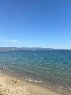 a person standing on a beach near the water at Sacré cœur in Ajaccio