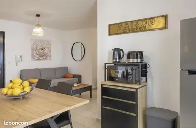 a living room with a couch and a table with a microwave at Appartement Lucciana Corse plage à 2 minutes in Lucciana