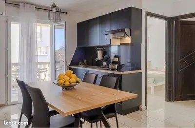 a kitchen with a table with a bowl of fruit on it at Appartement Lucciana Corse plage à 2 minutes in Lucciana