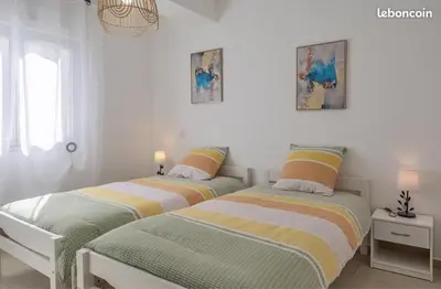two beds sitting next to each other in a bedroom at Appartement Lucciana Corse plage à 2 minutes in Lucciana