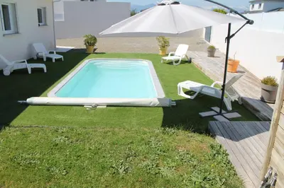 a swimming pool with an umbrella and two chairs and an umbrella at Villa Nova in Aléria