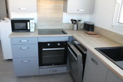 a kitchen with a counter with a microwave and a stove at Villa Nova in Aléria