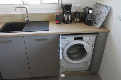 a kitchen counter with a washing machine and a sink at Villa Nova in Aléria