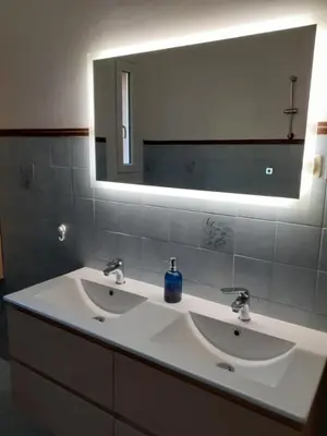 a bathroom with two sinks and a large mirror at Appartement T2 Alistro San Giuliano Corse in San-Giuliano