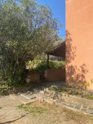 a building with a tree next to a sidewalk at Appartement T2 Alistro San Giuliano Corse in San-Giuliano
