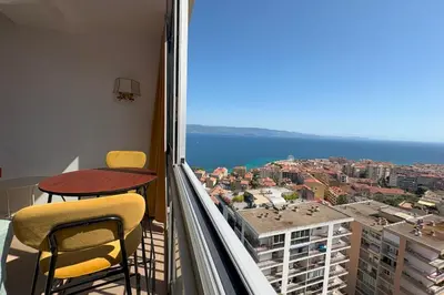 a balcony with two chairs and a table and the ocean at Fage - Panoramic view Spacious Luminous - by TGB in Ajaccio