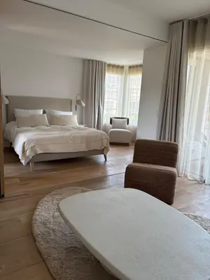 a white bedroom with a bed and a chair at T2 - sea and Corsican maquis in Bonifacio