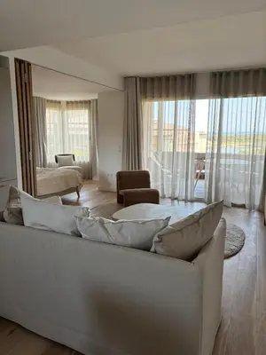 a living room with a white couch and a large window at T2 - sea and Corsican maquis in Bonifacio