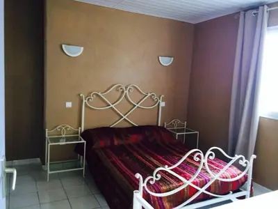 a bedroom with a white bed with a red blanket at APPARTEMENT 2 CHAMBRES PISCINE A PARATGEr in Porto-Vecchio