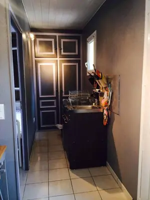 a small kitchen with a sink and a door at APPARTEMENT 2 CHAMBRES PISCINE A PARATGEr in Porto-Vecchio