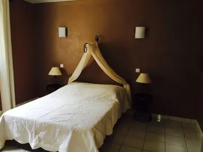 a bedroom with a white bed with a canopy at APPARTEMENT 2 CHAMBRES PISCINE A PARATGEr in Porto-Vecchio