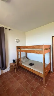 a room with two bunk beds and a flat screen tv at Gîte U Saltu in Solaro