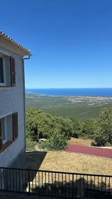 a house with a balcony with a view of a field at Gîte U Saltu in Solaro