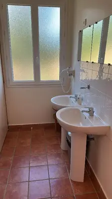 a bathroom with two sinks and a window at Gîte U Saltu in Solaro