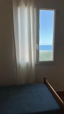a bedroom with a window with a view of the ocean at Gîte U Saltu in Solaro