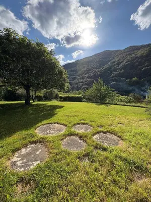a grassy field with a view of a mountain at Appartement rez de jardin - Casa San Cesaru in Bains de Guitera