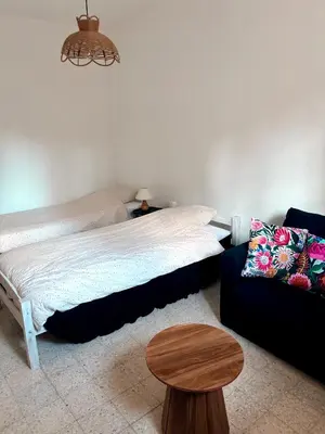 a bedroom with a bed and a table and a couch at Appartement rez de jardin - Casa San Cesaru in Bains de Guitera
