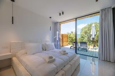 a white couch in a living room with a large window at Villa Cala Serena in Zonza