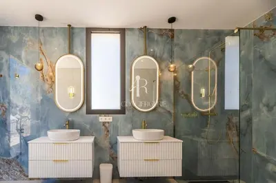 a bathroom with two sinks and two mirrors at Villa Cala Serena in Zonza