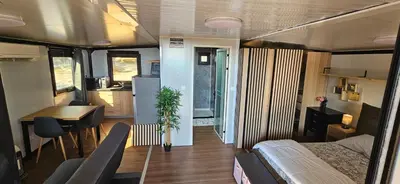 a room with a bed and a table and a kitchen at Grande Chambre tout confort 5 in Bonifacio