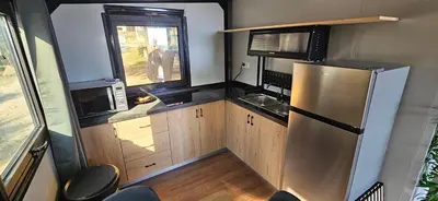 a small kitchen with a refrigerator and a window at Grande Chambre tout confort 5 in Bonifacio