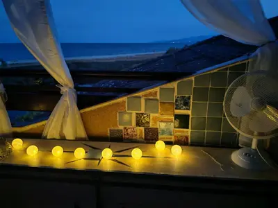 a room with a fan and candles on a counter at Le Rêve de Mer in Ghisonaccia
