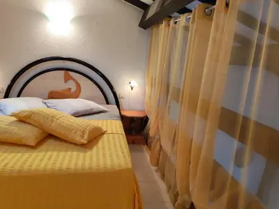 a bedroom with two beds with a wooden headboard at Le Rêve de Mer in Ghisonaccia