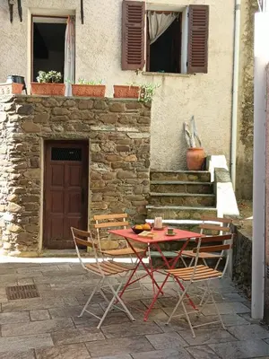 a table and chairs sitting in front of a building at Entre mer et montagne in Valle-di-Campoloro