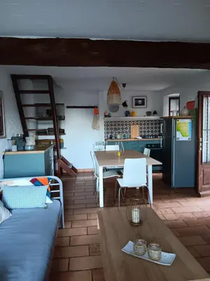 a kitchen and living room with a couch and a table at Entre mer et montagne in Valle-di-Campoloro