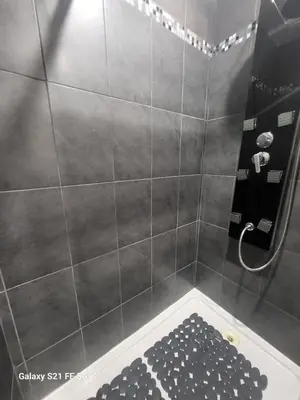 a bathroom with a shower with a black and white rug at T2 Ajaccio centre in Ajaccio