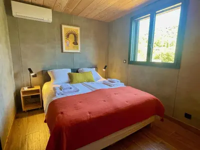 a bedroom with a bed with a red blanket and a window at Casa Paula in Serriera
