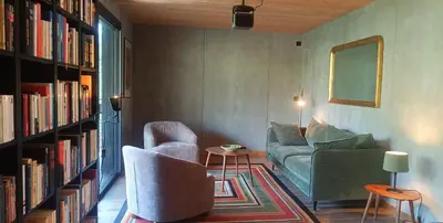 a living room with a couch and chairs and bookshelves at Casa Paula in Serriera