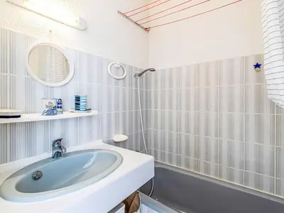 a bathroom with a sink and a mirror and a tub at Studio Marines de Moriani by Interhome in Moriani Plage