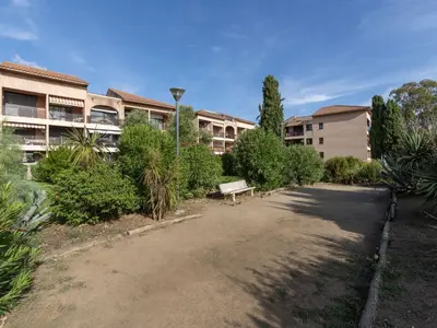 a park with a bench in front of a building at Studio Marines de Moriani by Interhome in Moriani Plage