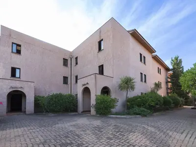a large brick building with a palm tree in front of it at Studio Marines de Moriani by Interhome in Moriani Plage