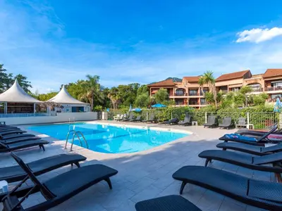 a swimming pool with lounge chairs in a resort at Studio Marines de Moriani by Interhome in Moriani Plage